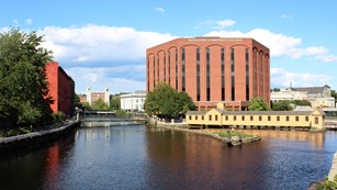 A canal weaves past a brick building