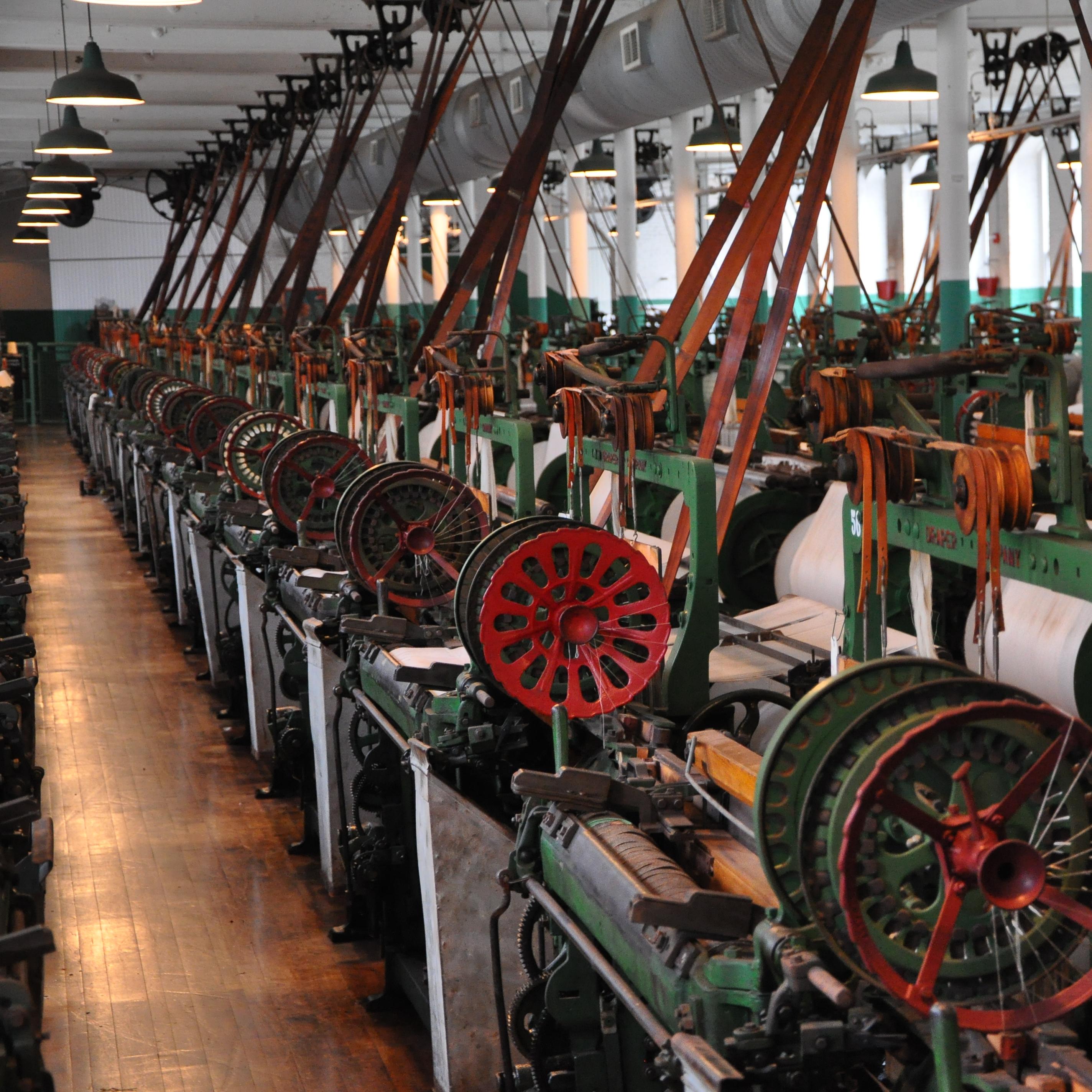 A room filled with rows of looms painted green