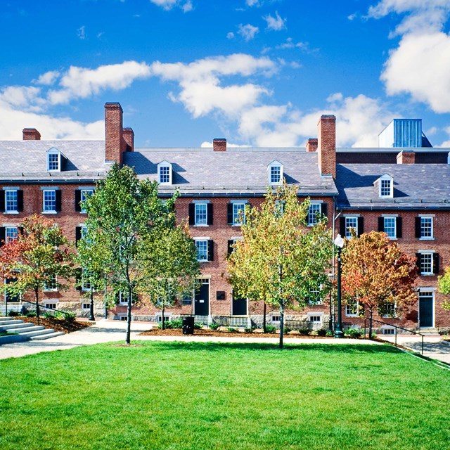 The present day boardinghouse behind a green lawn. 