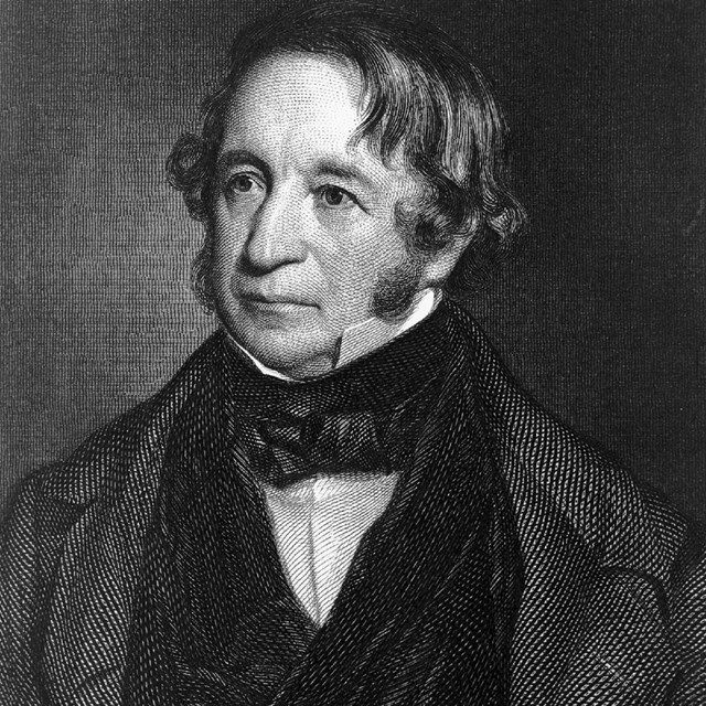 A man in a suit and bowtie facing forward and left