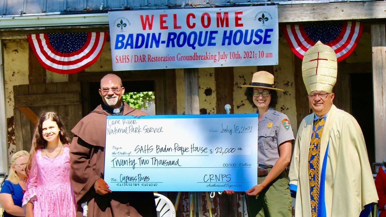 A group of people standing in front of the Badin-Roque House