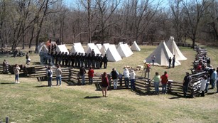Visitors watching a living history program at a reconstructed Union camp.
