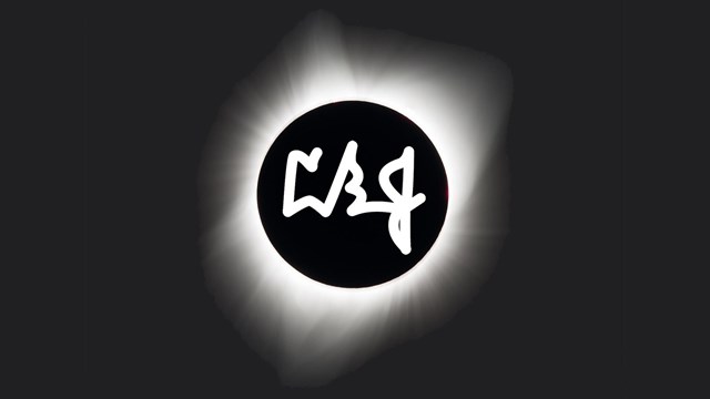 LBJ initials in white on top of a total eclipse highlighted by the sun's glowing corona.