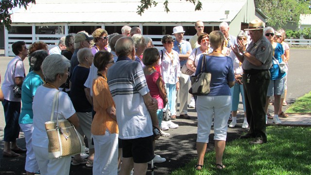 A ranger speaks to a large group of people.