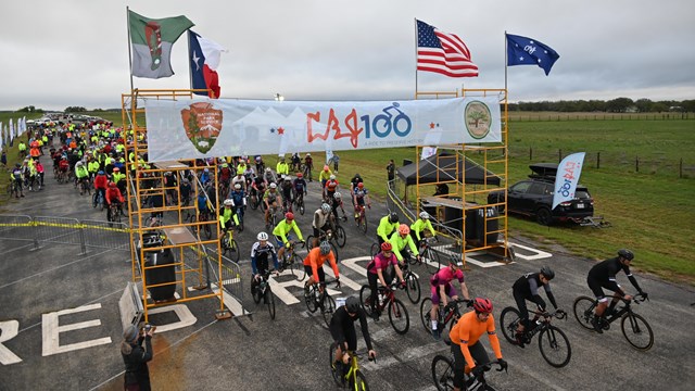 Start of a bike race, many bikers. Sign reads LBJ 100