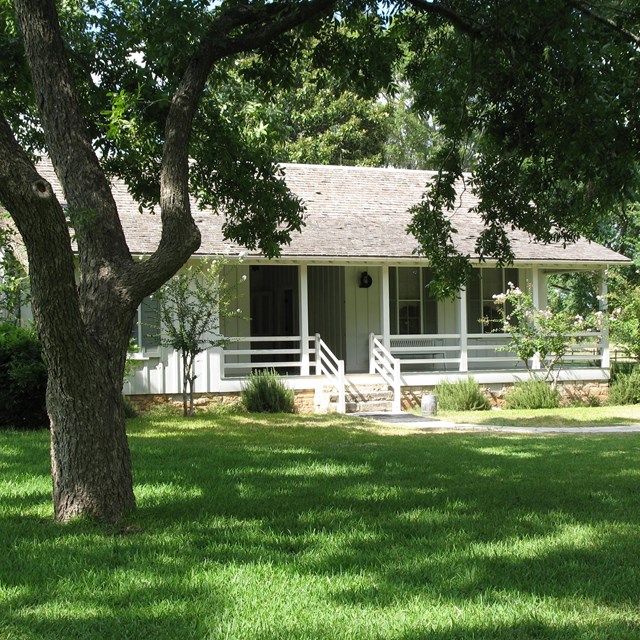 White Texas farmhouse with porch.