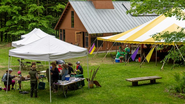 View from above of large event on lawn with tents and people walking around