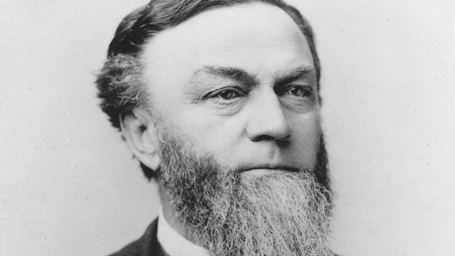 historic black and white photo of man around age 60 in suit with bow tie