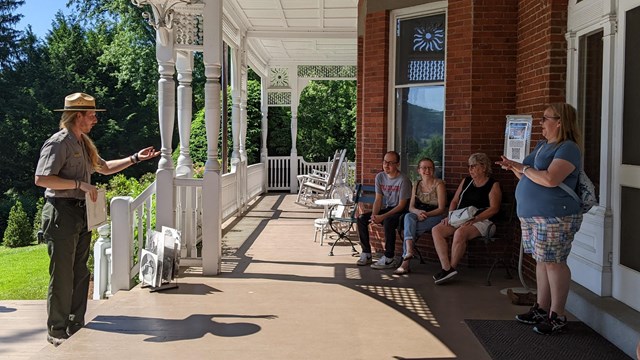 Ranger talks to a group of people on mansion porch