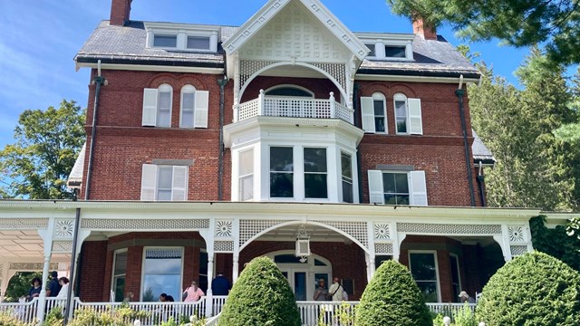 brick mansion with expansive porch