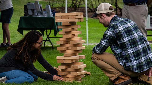 Two park visitors play giant Jenga outdoors
