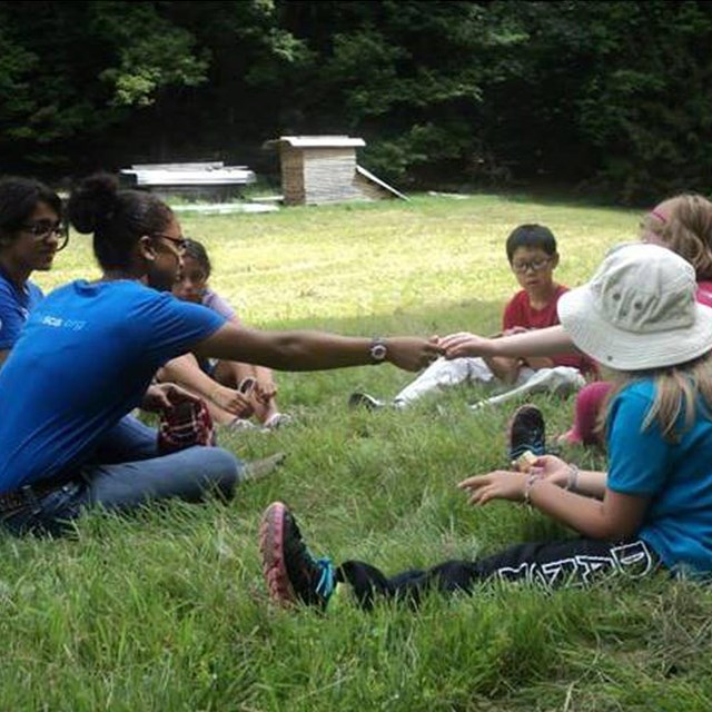 Students of different ages sit in circle in program together