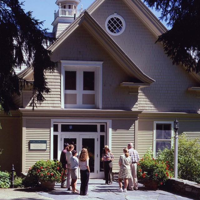 Carriage Barn Visitor Center with group and ranger