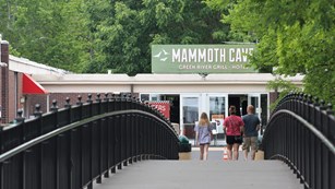 Small family crossing a scenic pedestrian bridge to the Lodge at Mammoth Cave.