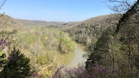 A view of the green river and surrounding hills