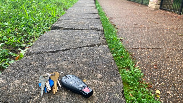 A set of car keys left on a rock wall. 