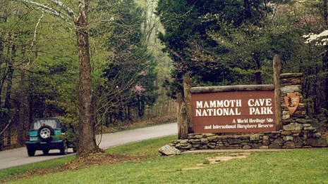 A car entering the park passing a sign reading