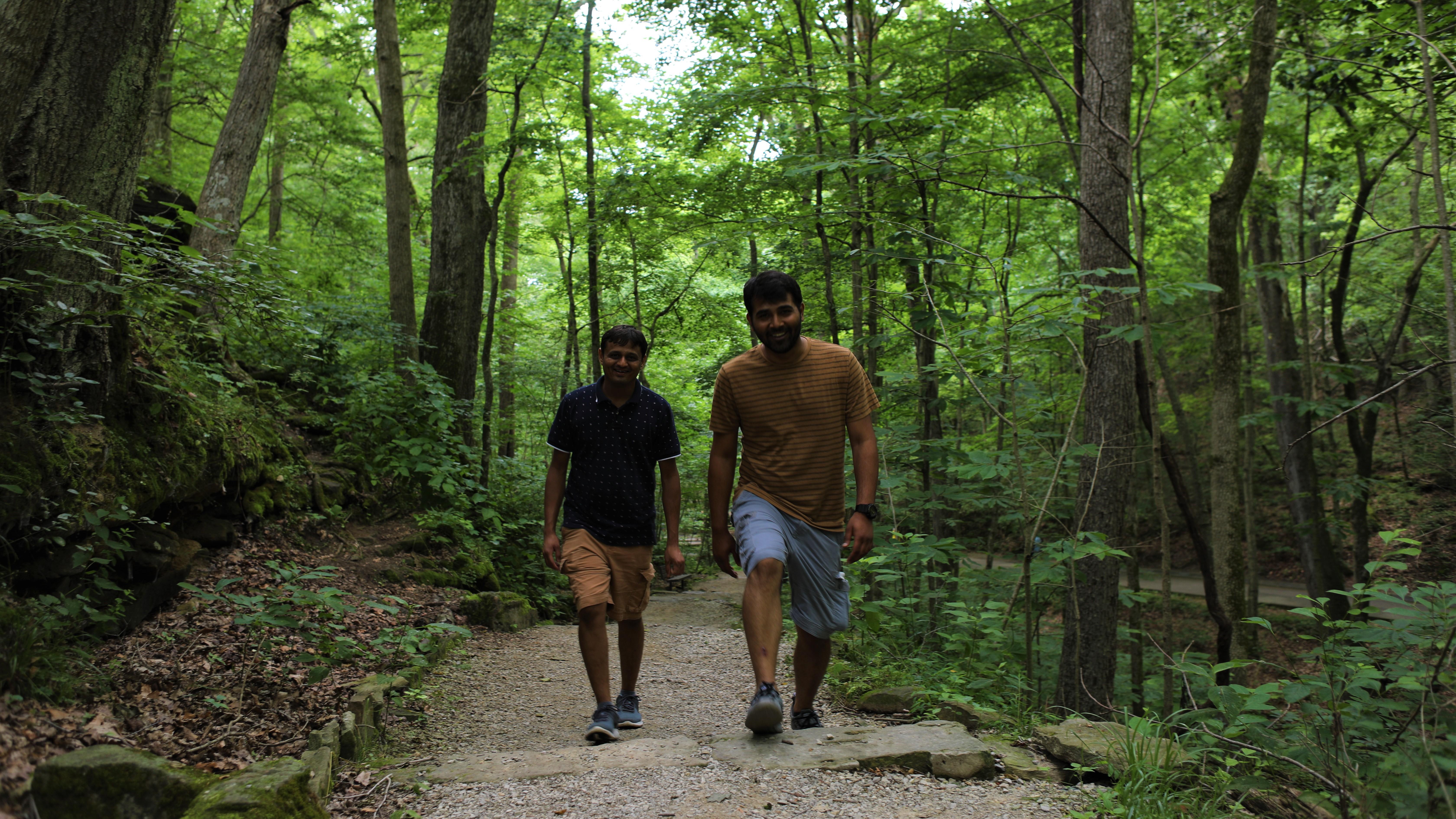 Two young men hike on a park trail