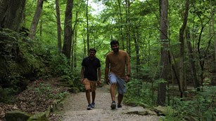 Two young men hike on a park trail