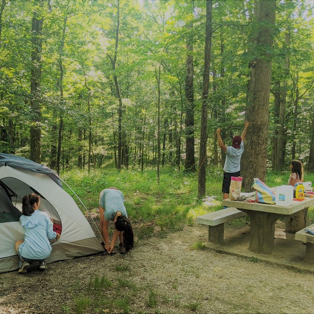 A family sets up their campsite.