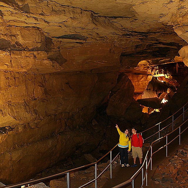 Two park visitors waling along a trail in the cave