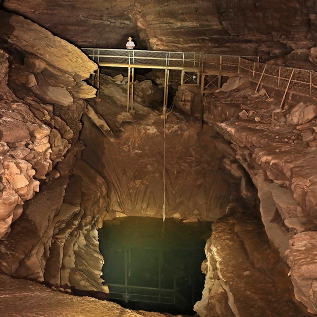 A small pool of water in a cave passage. 