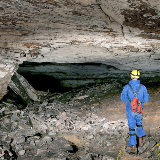 A cave explorer in a small cave passage. 