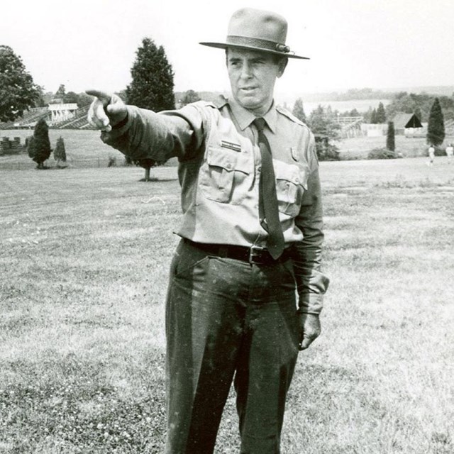 black and white photograph of a park ranger pointing