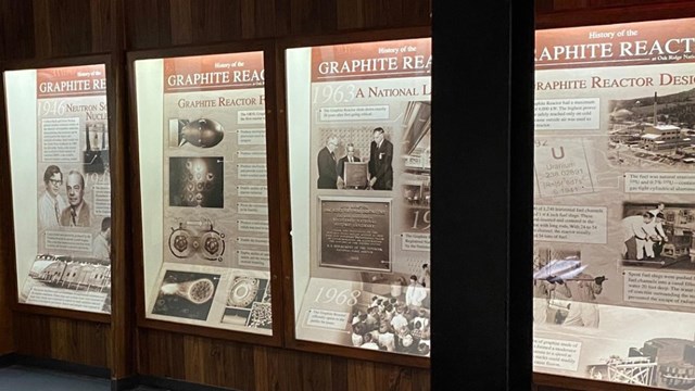 Lighted exhibit panels along the wall of a small room.
