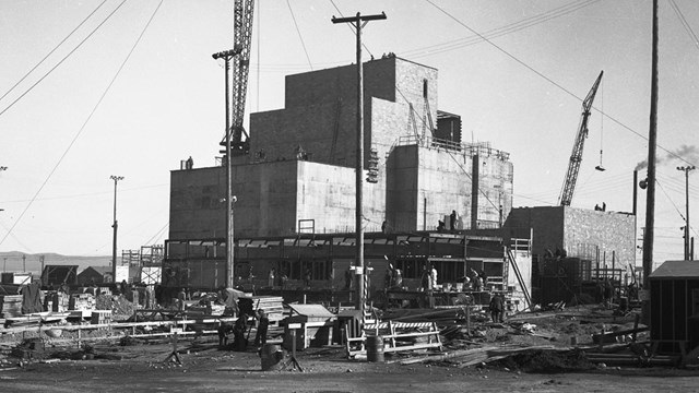 A black and white photo of a boxy, industrial-looking building. 