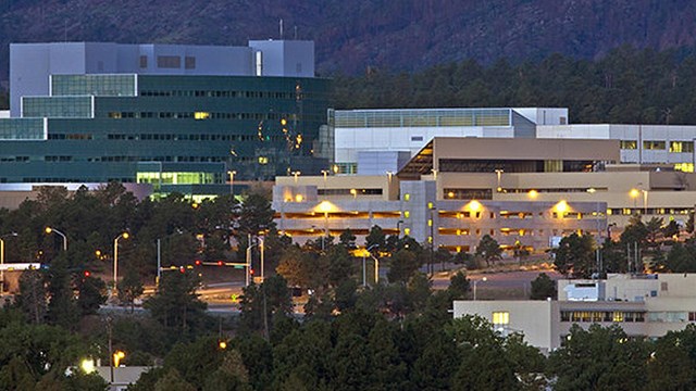 A group of large, modern looking buildings at twilight.