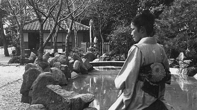 Black and white photo of several people on a busy Japanese street.