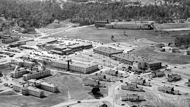 Aerial photo of industrial buildings amid rolling hills.