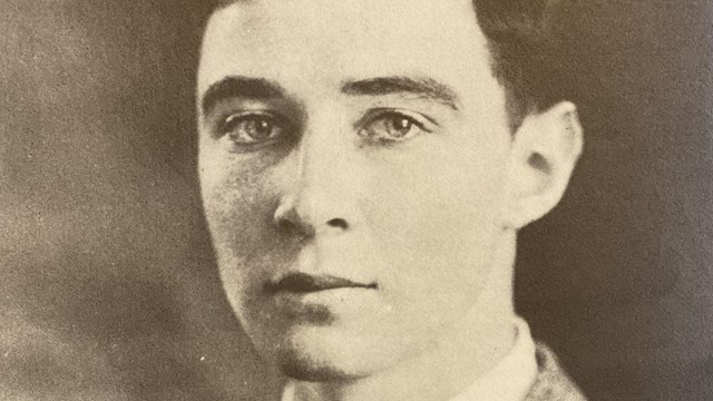 A black and white portrait of a man in a suit.