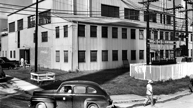 A black and white photo of an industrial building with many windows.  