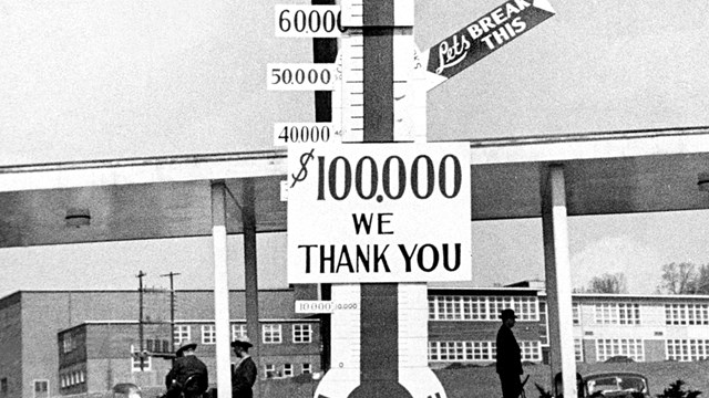 A black and white photo of a thermometer with dollar signs.