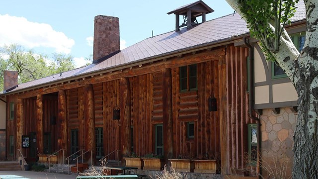 A large wooden lodge with a manicured lawn at the front.