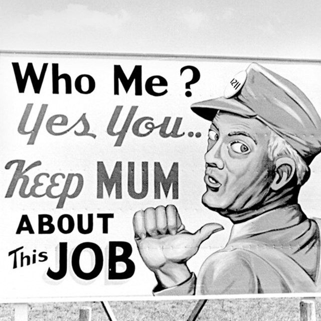 A billboard with a man on it reads: “Who me? Yes you... Keep mum about this job.”