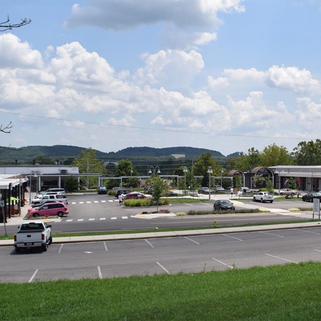 A small strip mall with parking in the foreground and background. 