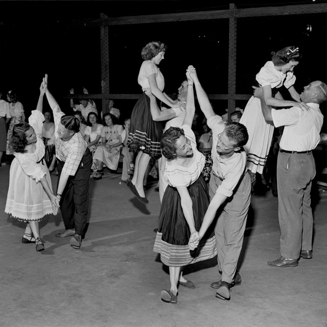 A black and white photo of people dancing in a gym.