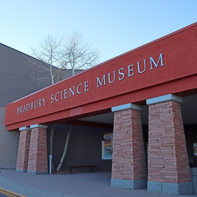 A brick building with red siding that says, 