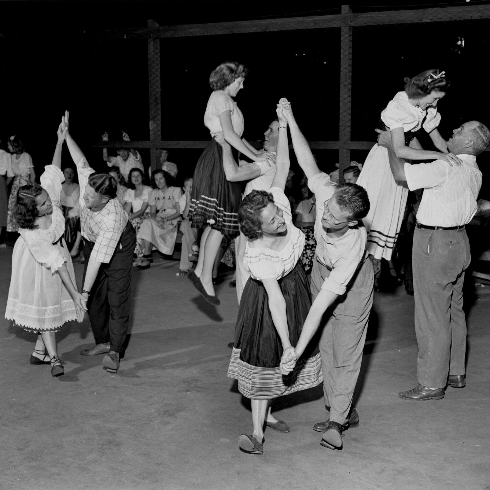 A black and white photo of 3 couple dancing.