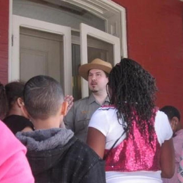 A ranger with a school group on the Maggie L. Walker house front porch