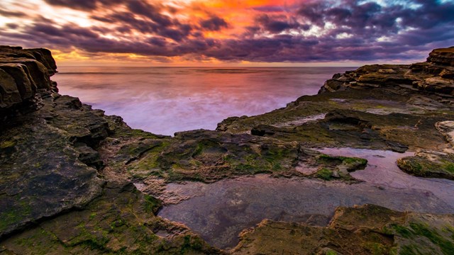 Colorful sunset reflected in the ocean and tidepools at Cabrillo National Monument
