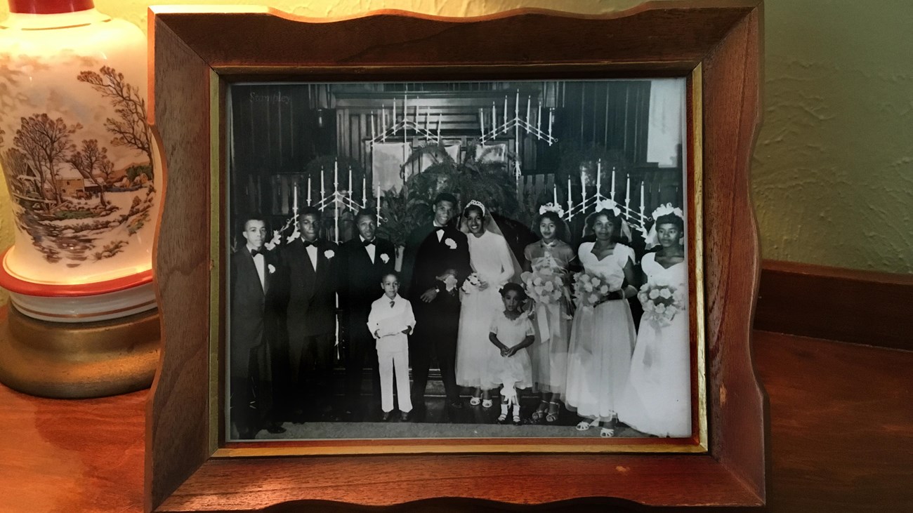 Medgar and Myrlie Evers wedding photo within wooden frame on end table next to lamp