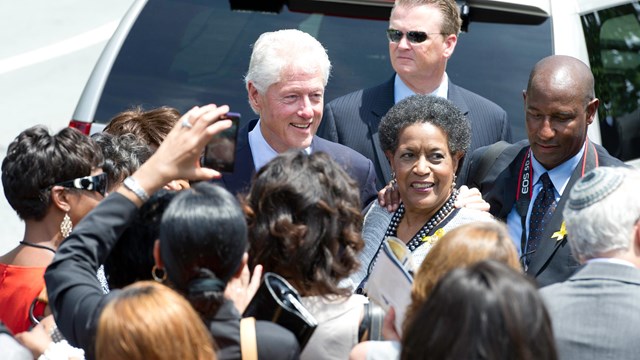Myrlie Evers-Williams and President Clinton surrounded by press