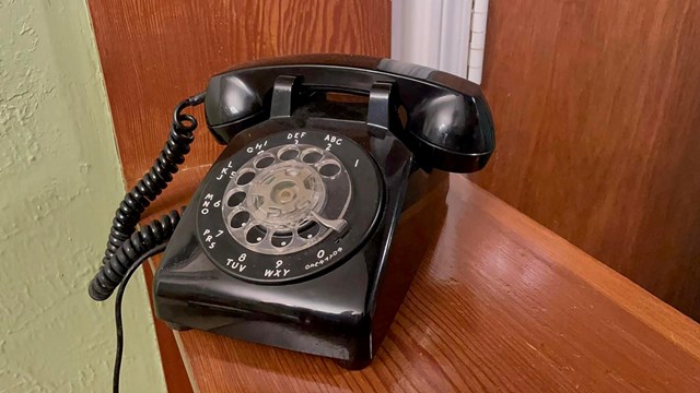 Black rotary telephone with spiral cord