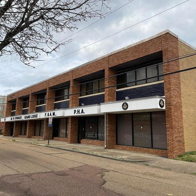 Rectangular brick building labeled MW Stringer Grand Lodge 