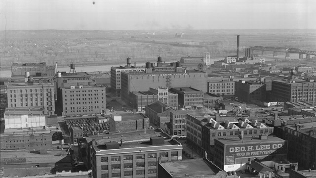Black and white photo of a historic downtown area and river from a high angle.