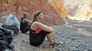 Two women sit gazing at the river.